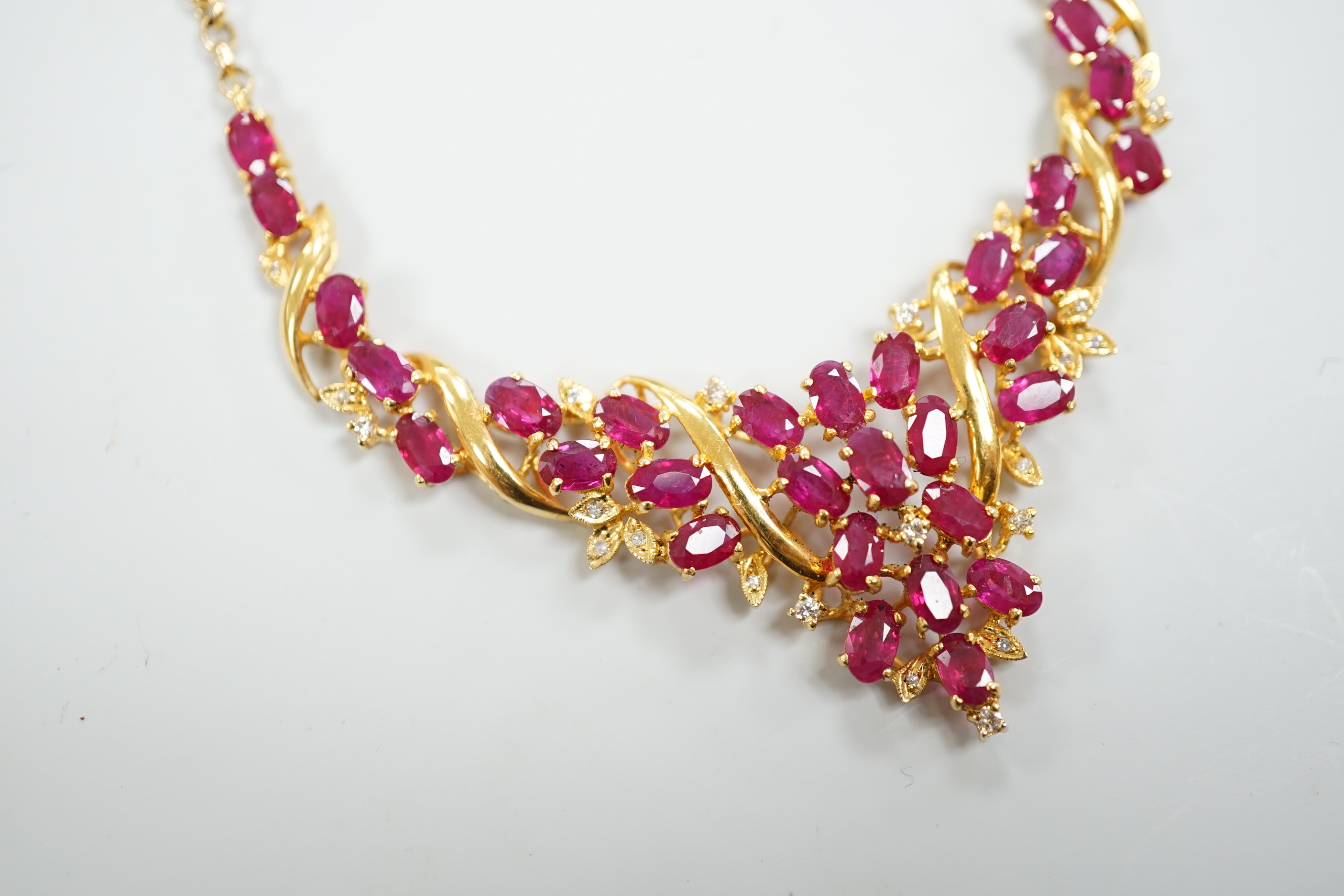 A 20th century Indian yellow metal, ruby and diamond chip cluster set necklace, with later 375 chain, 52cm, gross weight 12.2 grams.